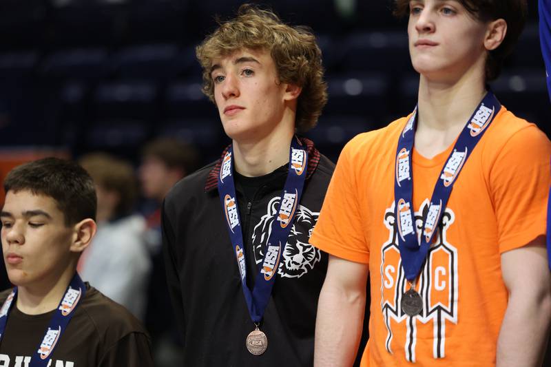 Plainfield North’s Maddox Garbis stands on the podium after taking fourth place in the 120-pound Class 3A third place match on Saturday, Feb. 17th, 2024 in Champaign.