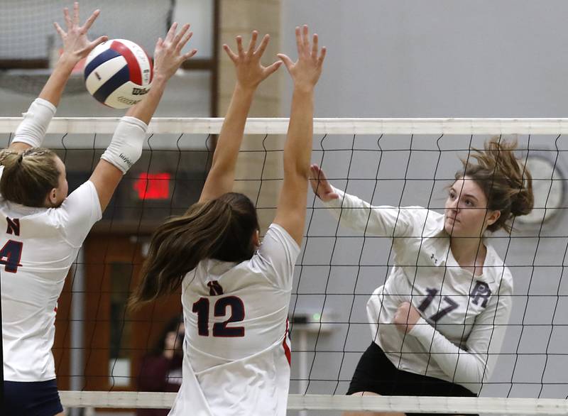 Prairie Ridge's Mackenzie Schmidt hits the ball through the block of Belvidere North's Bree Messenger (left) and Milania Galluzzo during the Class 3A Woodstock North Sectional finals volleyball match on Wednesday, Nov. 1, 2023, at Woodstock North High School.