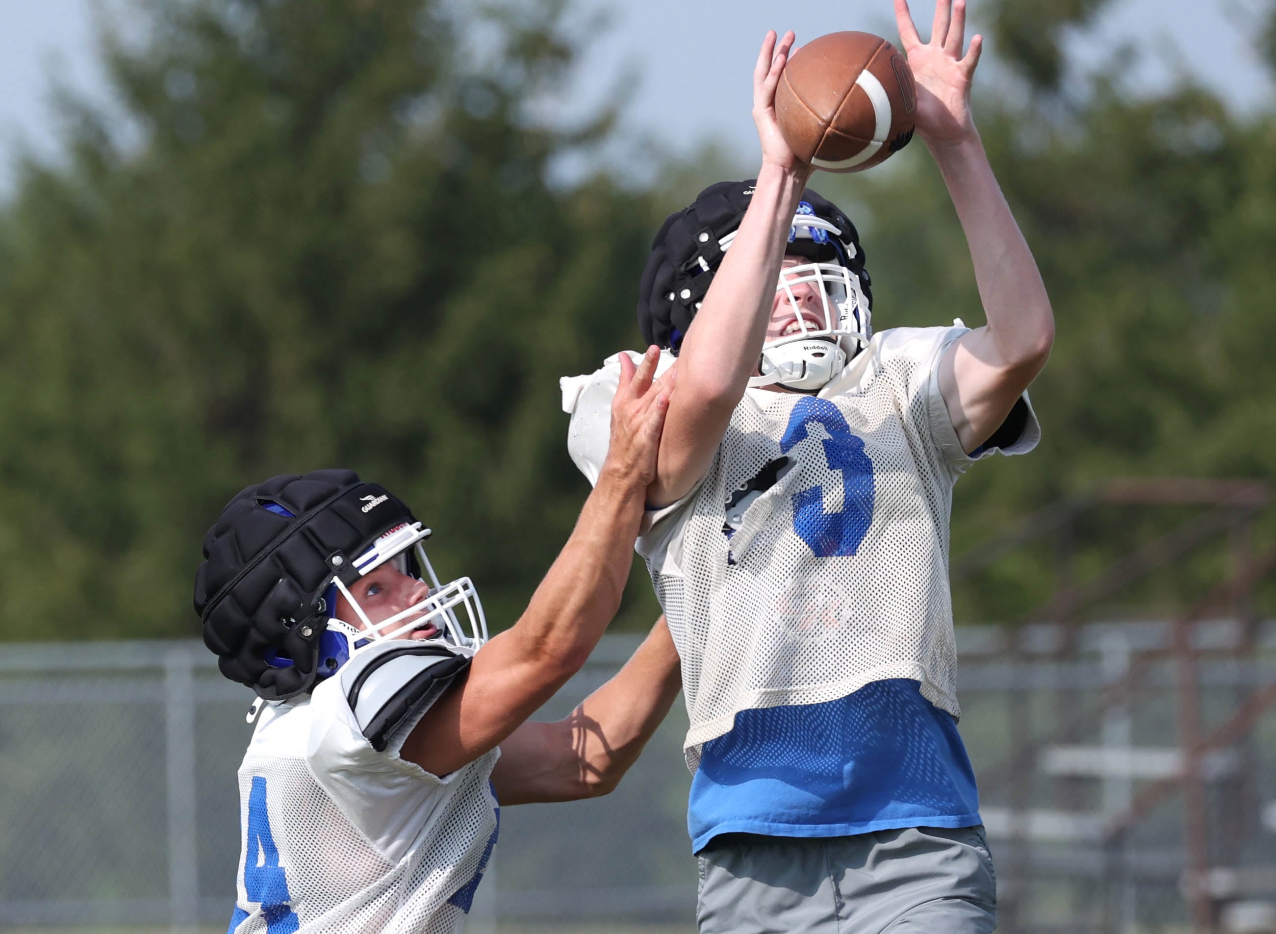 Genoa-Kingston’s Nolan Kline (right) catches a pass during practice Wednesday, Aug. 14, 2024, at the school in Genoa.