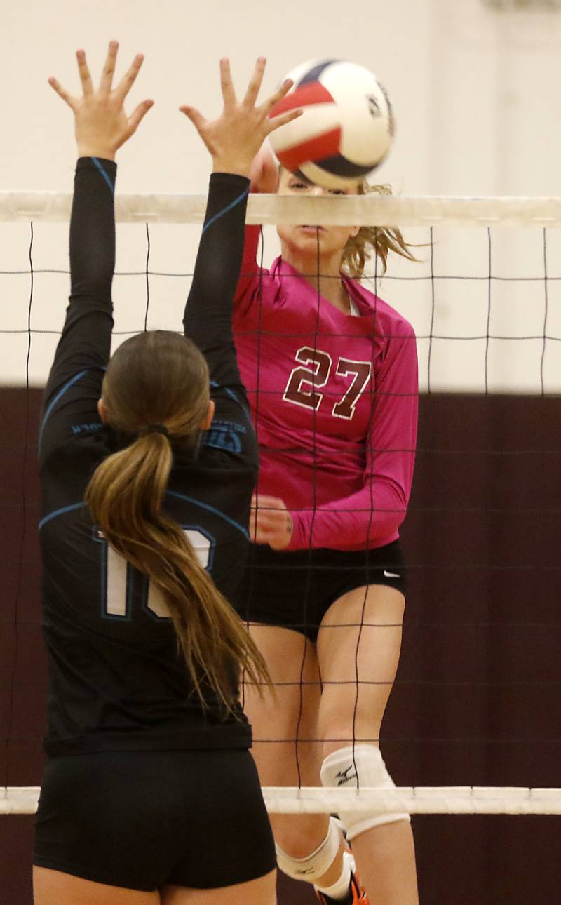 Richmond-Burton's Dani Hopp hits the ball past the block of Woodstock North’s Gabriella Schefke during a Kishwaukee River Conference volleyball match Wednesday, Oct.11, 2023, at Richmond-Burton Community High School.