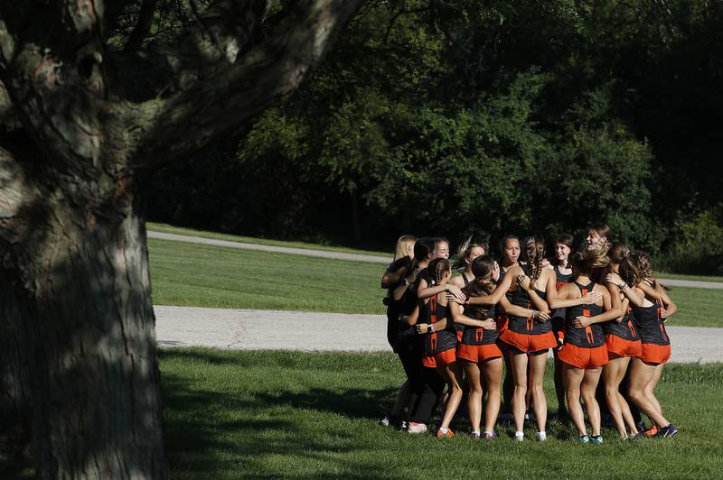 Members of the Crystal Lake Central cross country team get fired up before the start of during the girls race of the McHenry County Cross Country Meet Saturday, August 27, 2022, at Emricson Park in Woodstock.