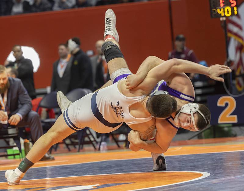 IC Catholic’s Michael Calcagno and Rochelle’s Kaiden Morris (right) hit the mat in the 2A 215 pound championship match Saturday, Feb. 17, 2024 at the IHSA state wrestling finals at the State Farm Center in Champaign.