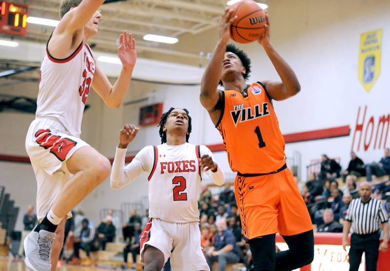 Romeoville's Mickeis Johnson (1) shoots against Yorkville defenders Jason Jakstys and Michael Dunn (2) during a varsity basketball game at Yorkville High School on Friday, Jan. 19, 2024.