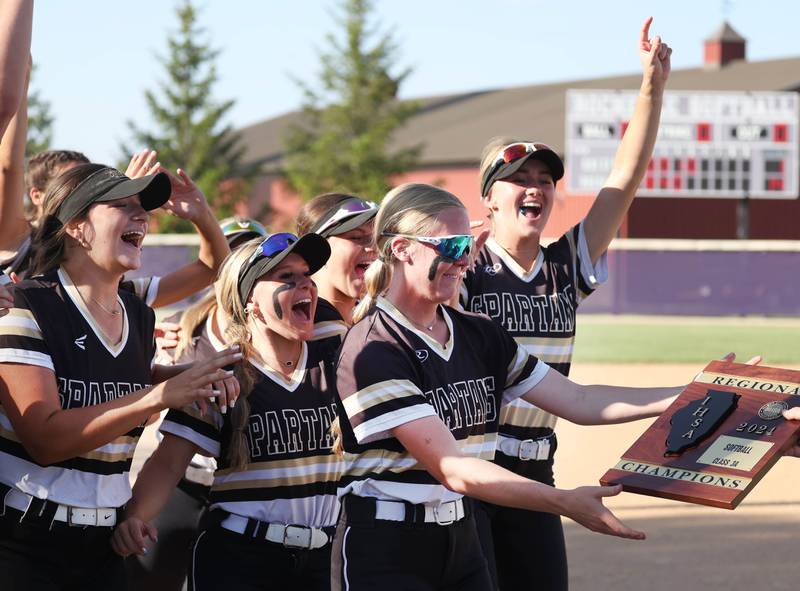 Sycamore players celebrate as they receive the Class 3A regional champions plaque after beating Dixon Thursday, May 23, 2024, at Rochelle High School.