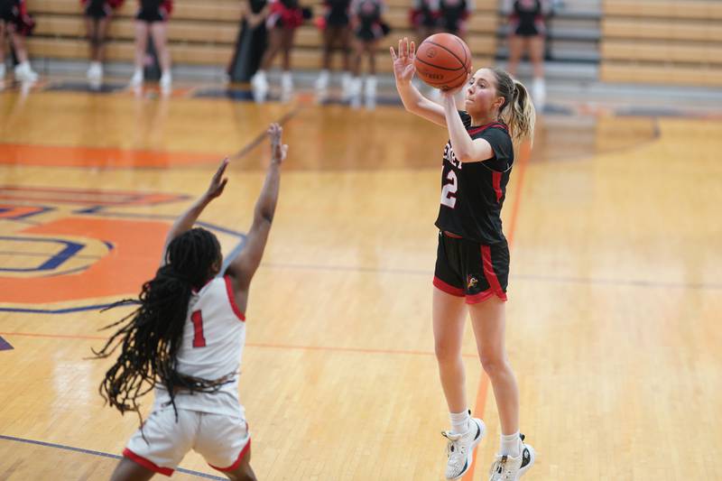 Benet’s Lindsay Harzich (12) shoots a three pointer against Bolingbrook's Airyel Jackson (1) during a Oswego semifinal sectional 4A basketball game at Oswego High School on Tuesday, Feb 20, 2024.