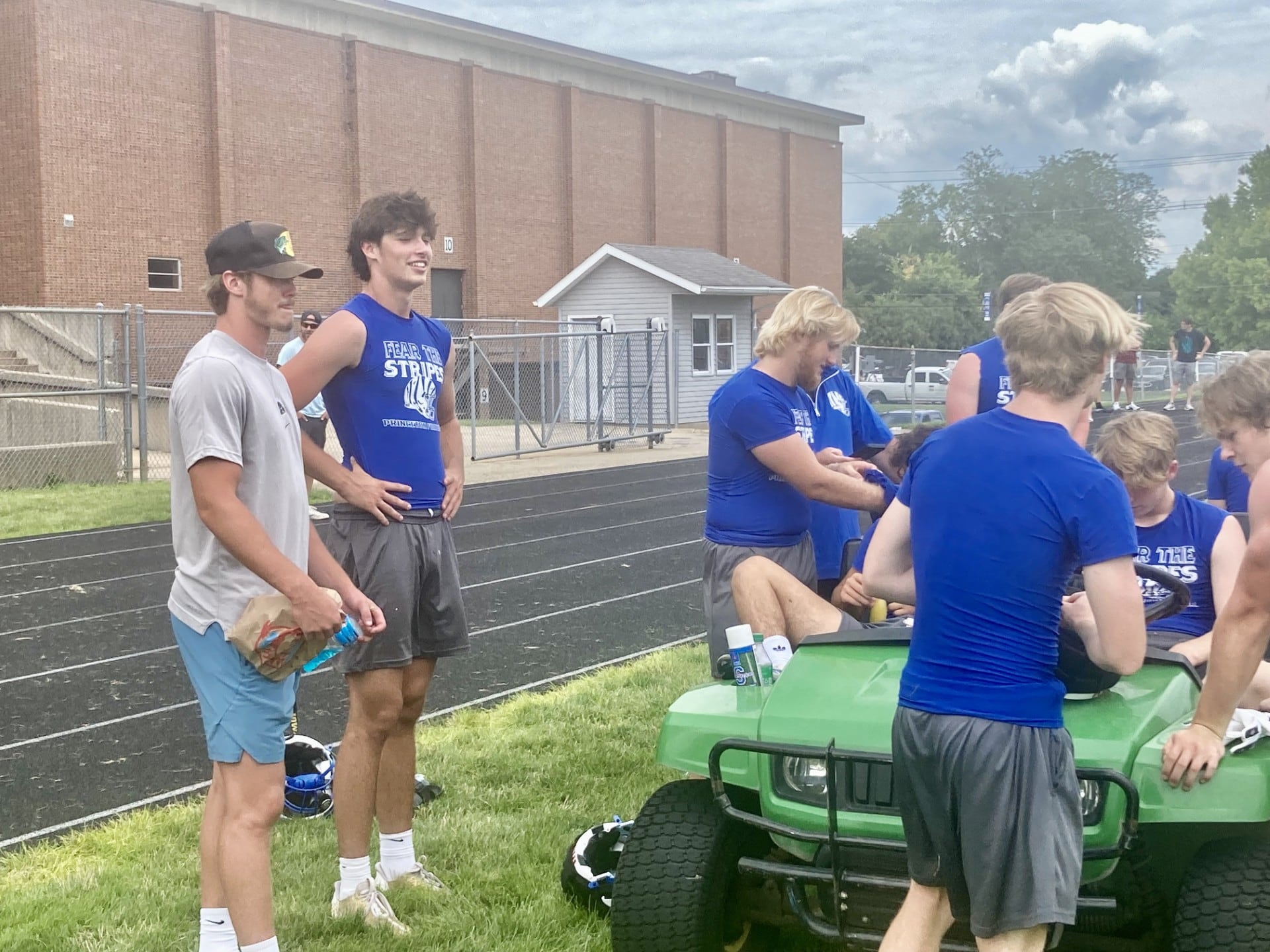 Teegan Davis (left), a 2023 Princeton grad and current Iowa Hawkeye, talkings football with PHS senior Noah LaPorte and other Tigers during Saturday's 7 on 7 at Bryant Field.