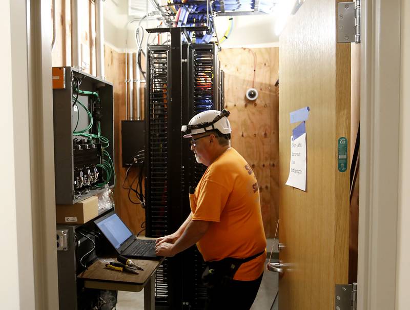 A construction worker works the communications wiring on Friday, April 21, 2023, as construction continues on the new MercyHealth hospital in Crystal Lake. The hospital is ramping up hiring as it gets set to open in this summer.