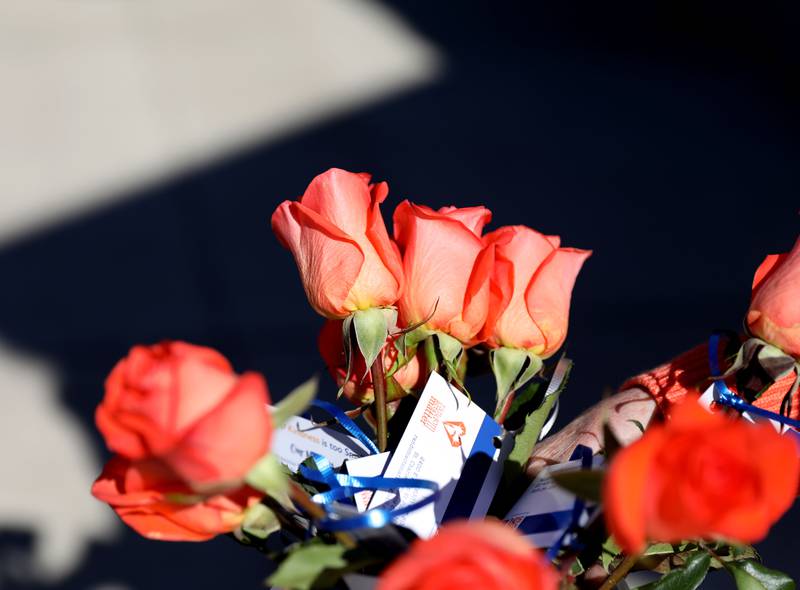 Volunteers from Random Acts Matter hand out orange roses Random Acts of Kindness week on First Street in St. Charles on Wednesday, Feb. 14, 2024.