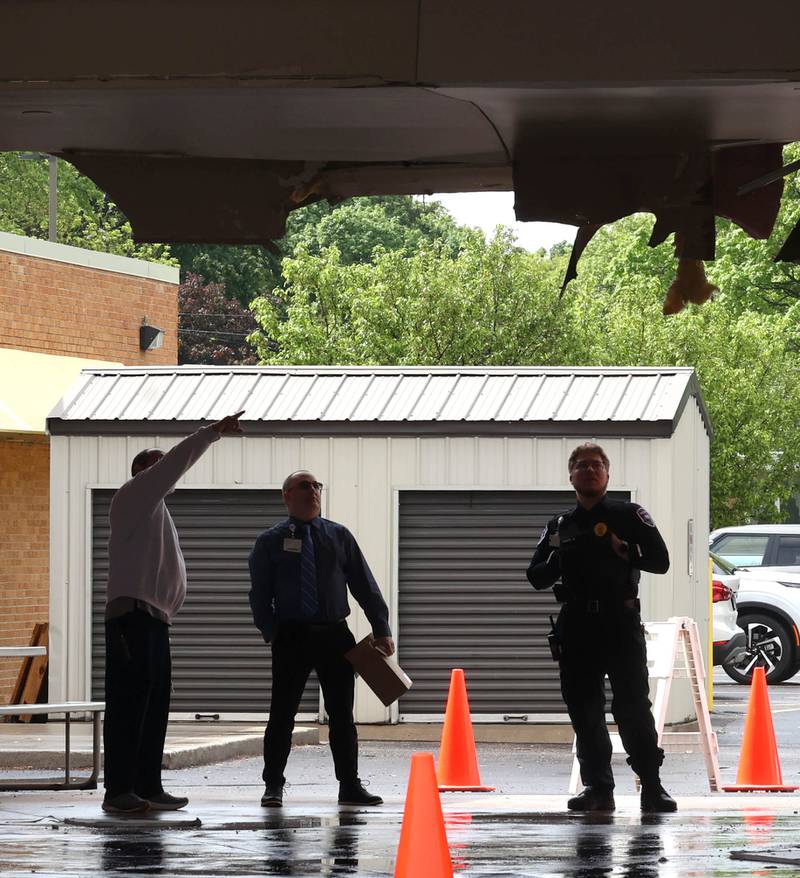 Northwestern Medicine Valley West Hospital employees look at the damage in the ambulance bay after a truck too tall for the clearance tried to drive through it Tuesday, May 7, 2024, at the hospital in Sandwich. There was visible damage to the ceiling of the bay with insulation a wall material hanging down.