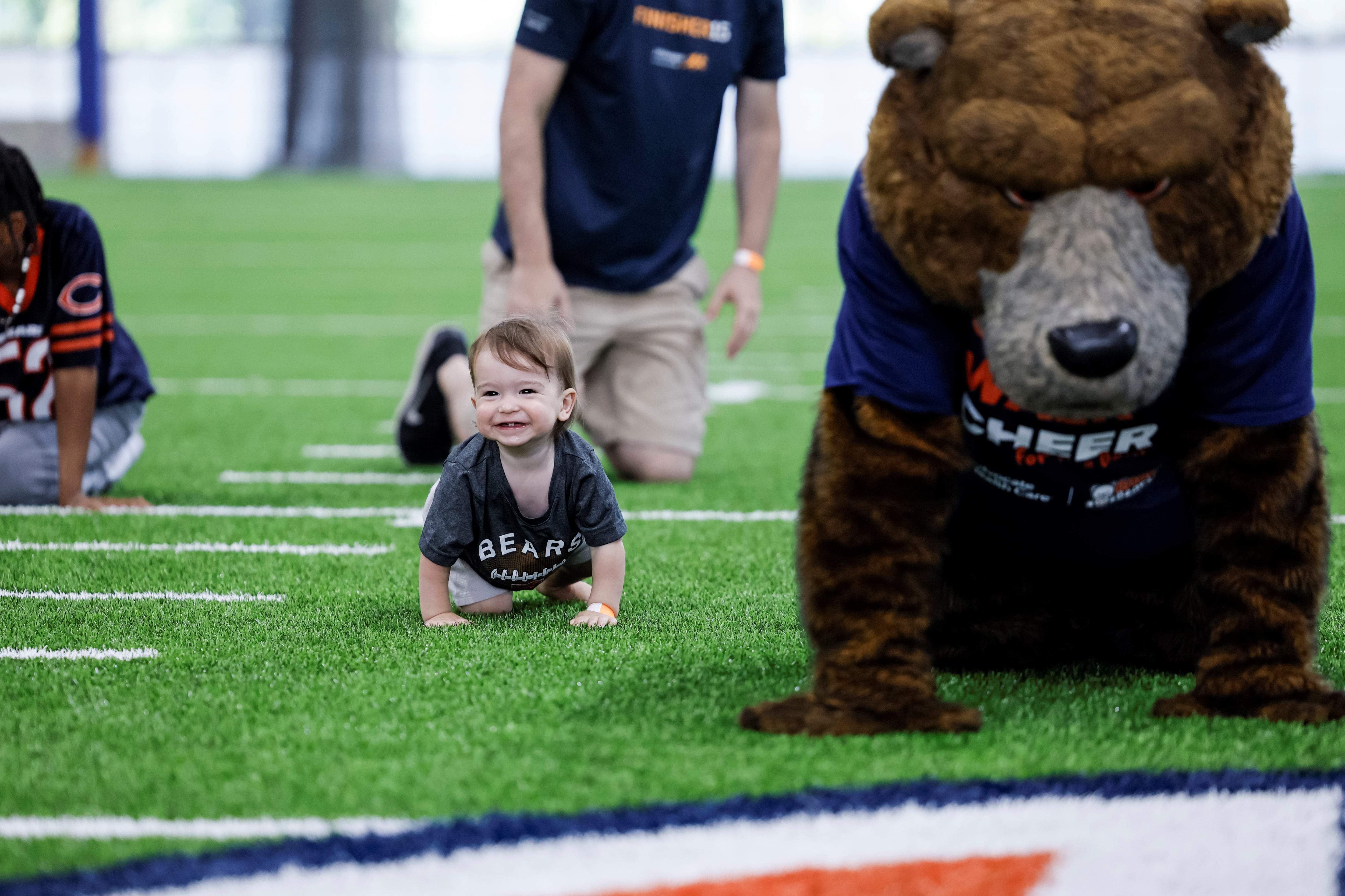 Baby Micah crawls his way to victoryin the annual Advocate Health Care Baby Bear Crawl at Halas Hall.