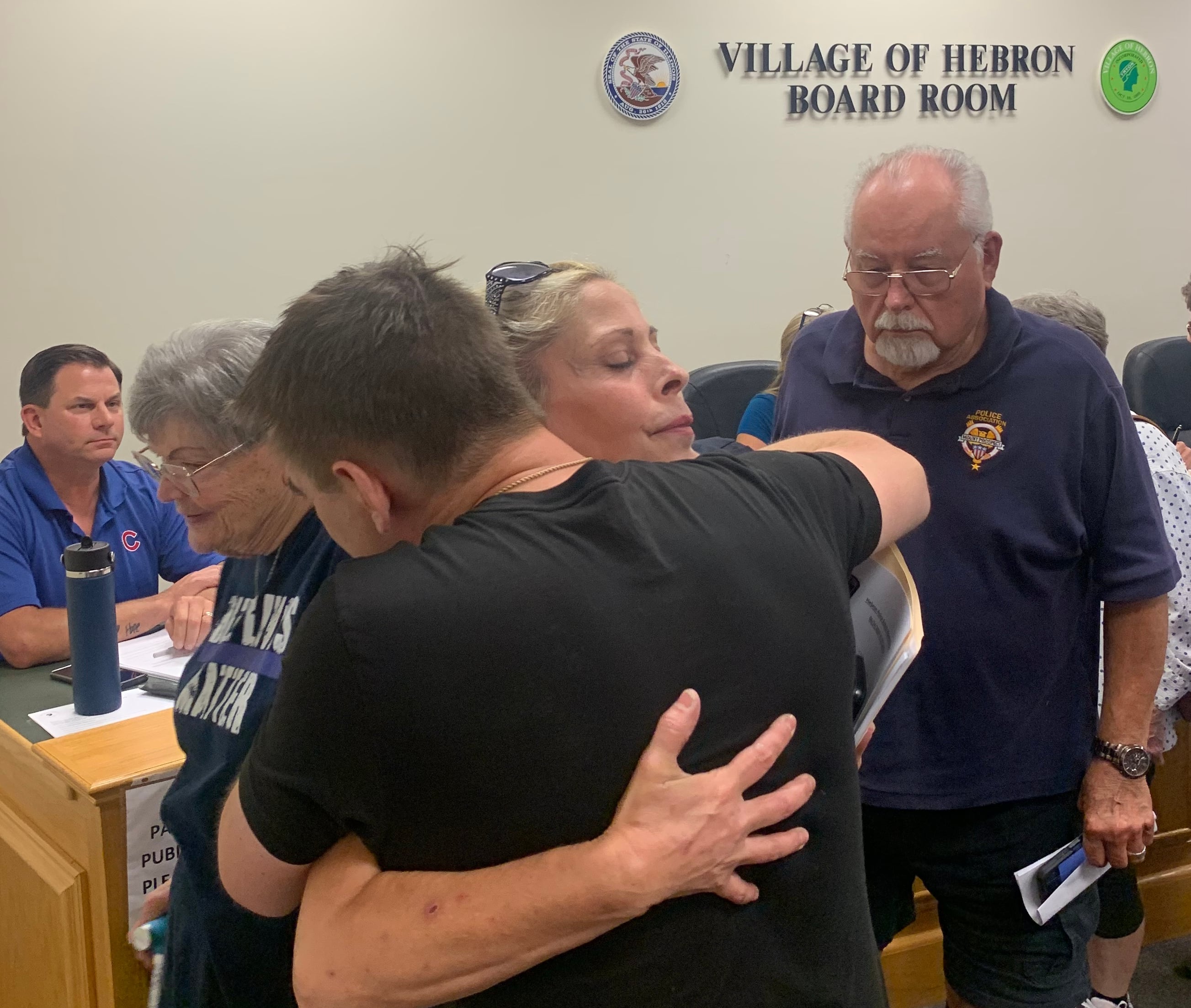 Hebron Police Chief Juanita Gumble receives a hug at a village board meeting at which the board voted to dismiss her on July 22, 2024.