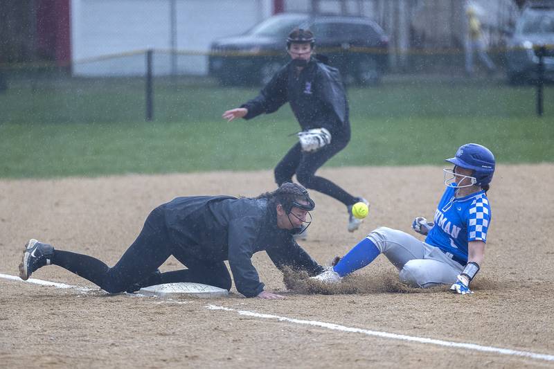 Dixon’s Elly Brown can’t corral a throw as Newman’s Lucy Oetting slides in safe at third Thursday, April 11, 2024 at Reynolds Field in Dixon.