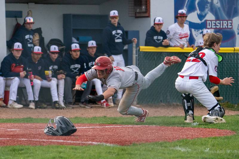 Yorkville's Sebastian Westphal (11) beats the throw to the plate for a score against West Aurora's Brady Smith (22) during a baseball game at West Aurora High School on Monday, April 24, 2023.