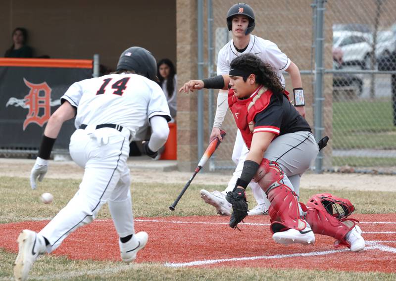 DeKalb’s Brodie Farrell scores ahead of the throw to East Aurora catcher Cristobal Ruiz during their game Wednesday, March 13, 2024, at DeKalb High School.