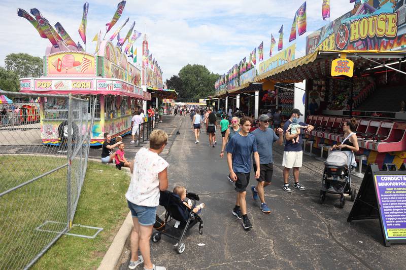 People walk between the rows of carnival games and food trucks at Plainfield Fest on Saturday June 29, 2024.