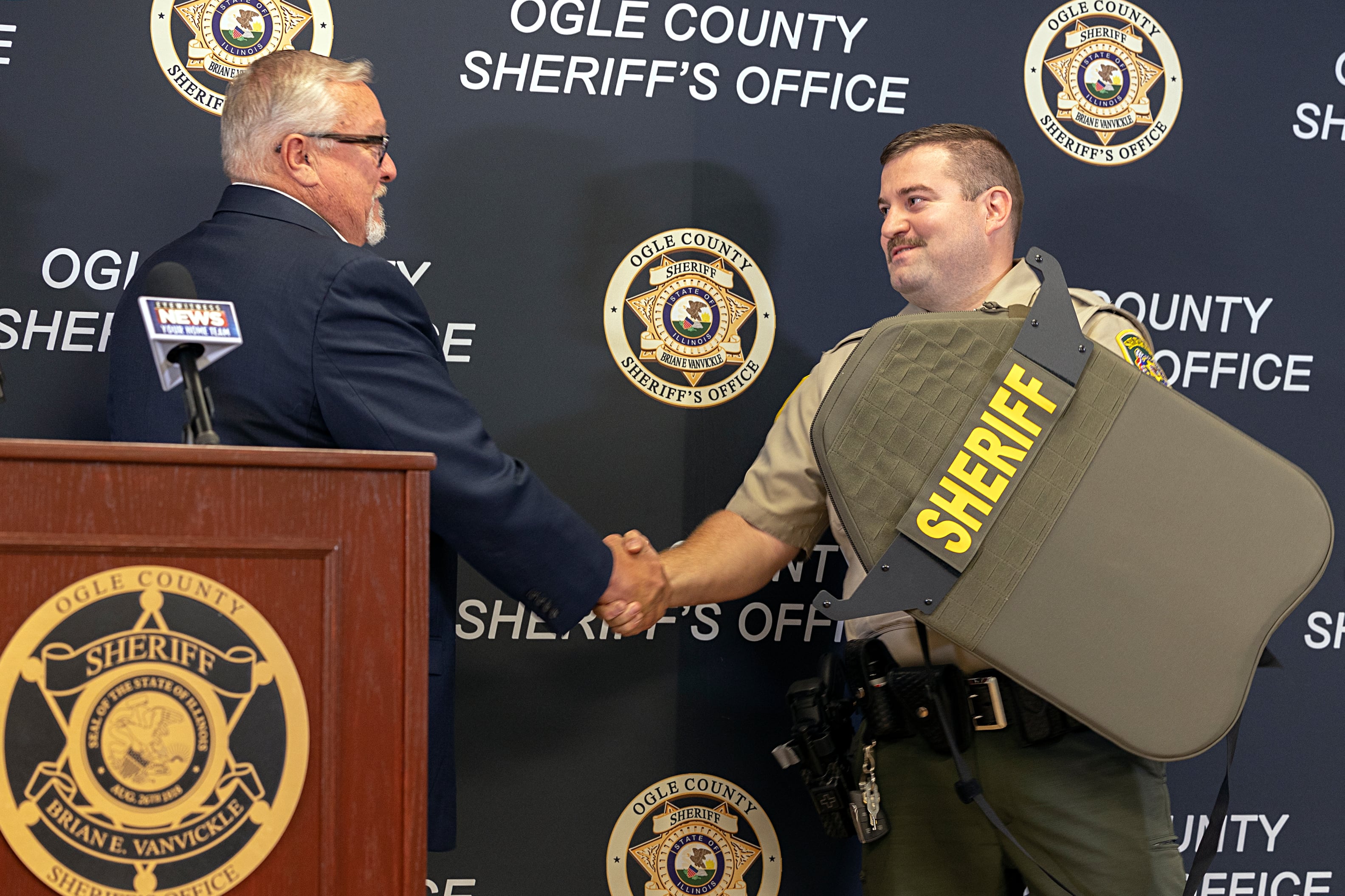 Armor Research Company CEO Ken Hall presents Ogle County Sheriff's Office Sgt. Tad Dominski with a new shield Tuesday, Aug. 20, 2024, at the sheriff’s office in Oregon. Dominski’s shield was damaged by gunfire June 12 in Lost Lake.