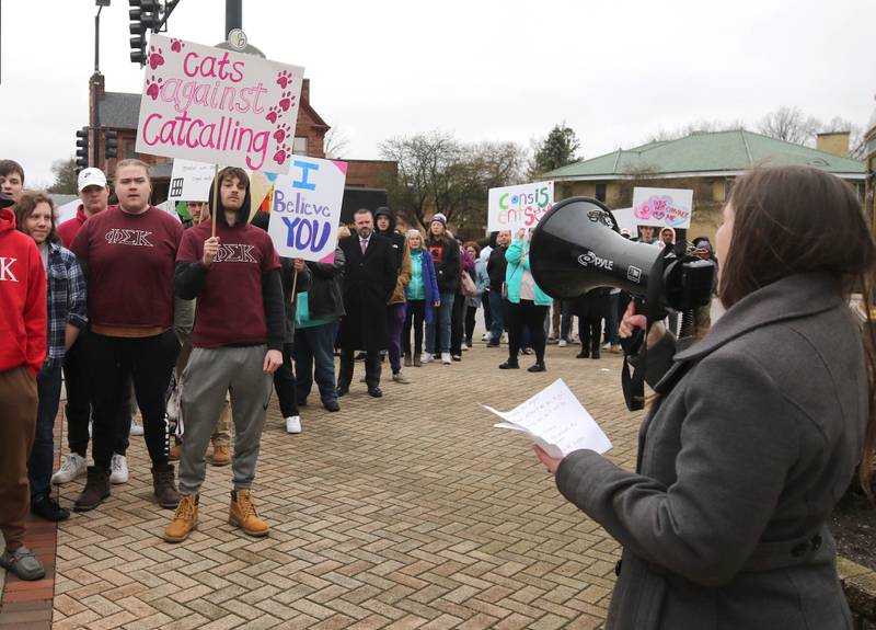 Marchers pause in Memorial Park at the corner of Lincoln Highway and First Street Tuesday, April 2, 2024, during Take Back the Night at the in DeKalb. The event, hosted by Safe Passage, is in honor of Sexual Assault Awareness Month and featured speakers and a march.