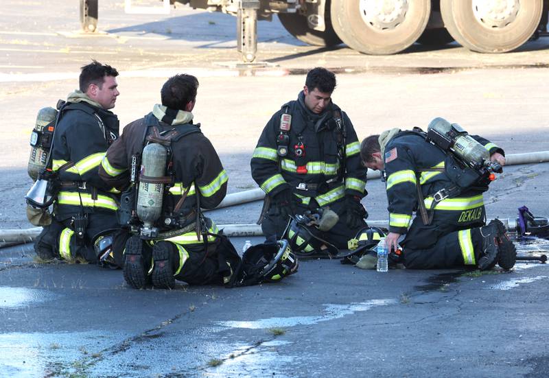 DeKalb firefighters try to cool off after battling a structure fire Friday, Sept. 1, 2023, in the building that once housed Fanatico Italian restaurant at 1215 Blackhawk Road in DeKalb.