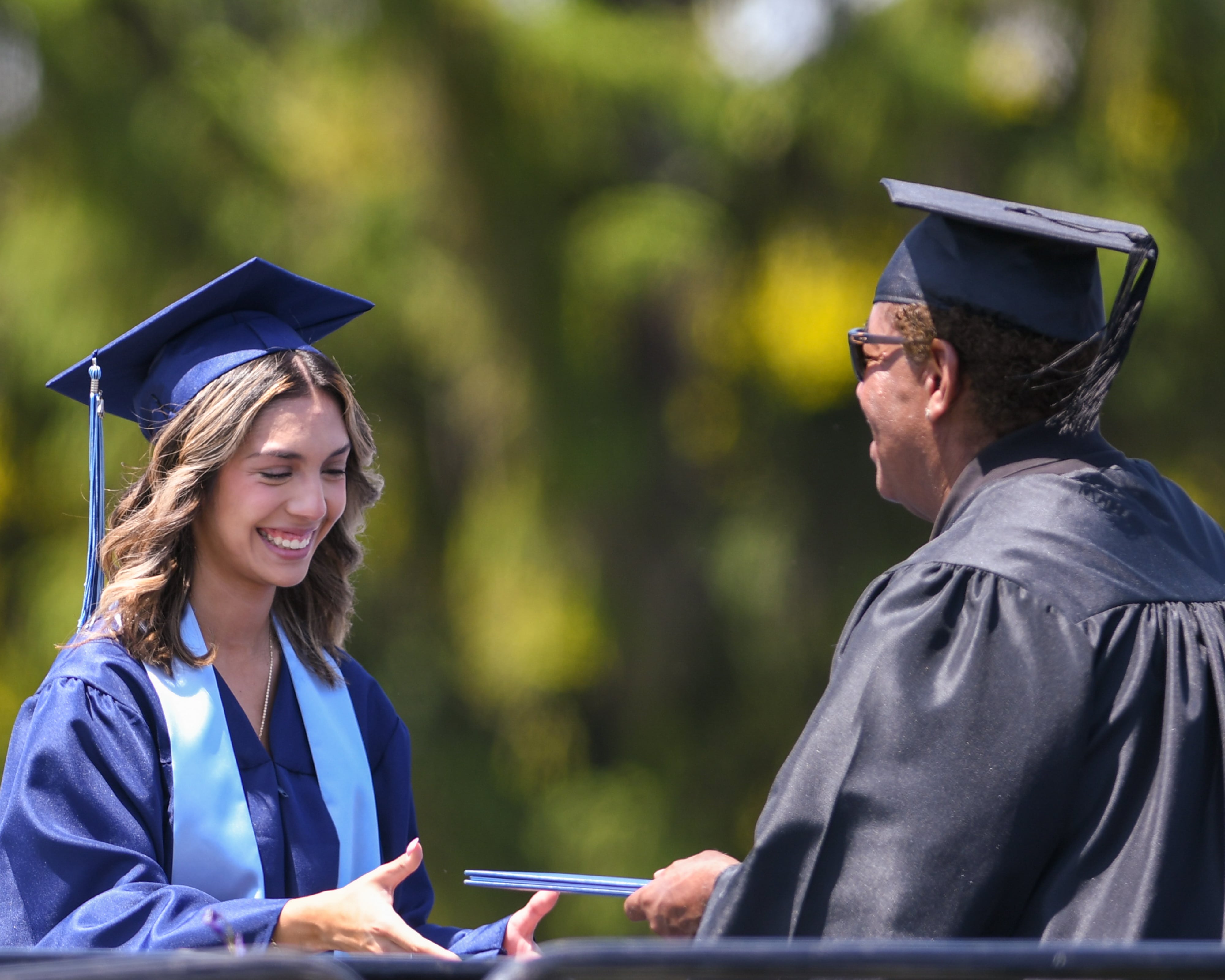 A Downers Grove South Senior is all smiles as she receives her diploma on Sunday May 19, 2024, at Downers Grove South High School.