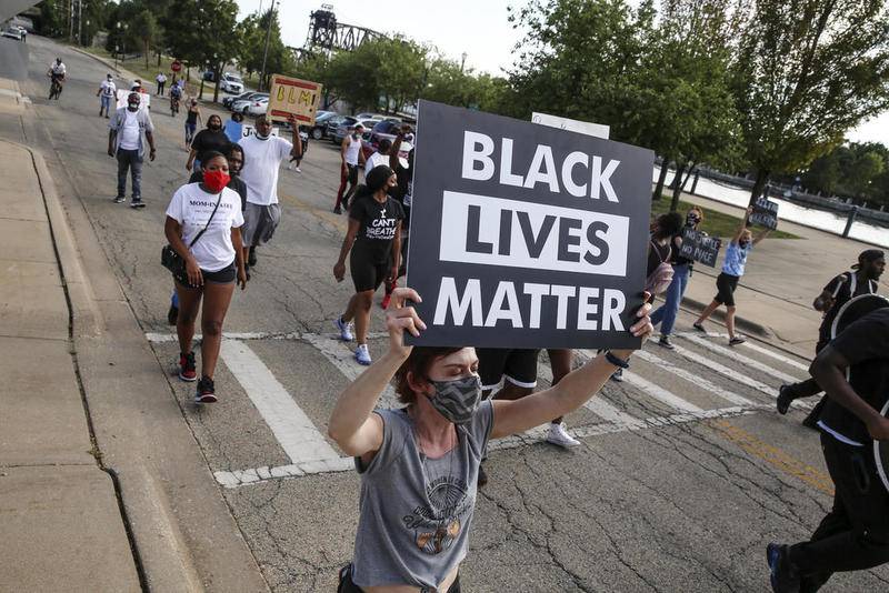 Demonstrators can be seen protesting outside Joliet City Hall, the Will County Courthouse and the Joliet Police Department on Saturday, Aug. 22, 2020, in response to the January 28 overdose death of Eric Lurry who died in police custody.