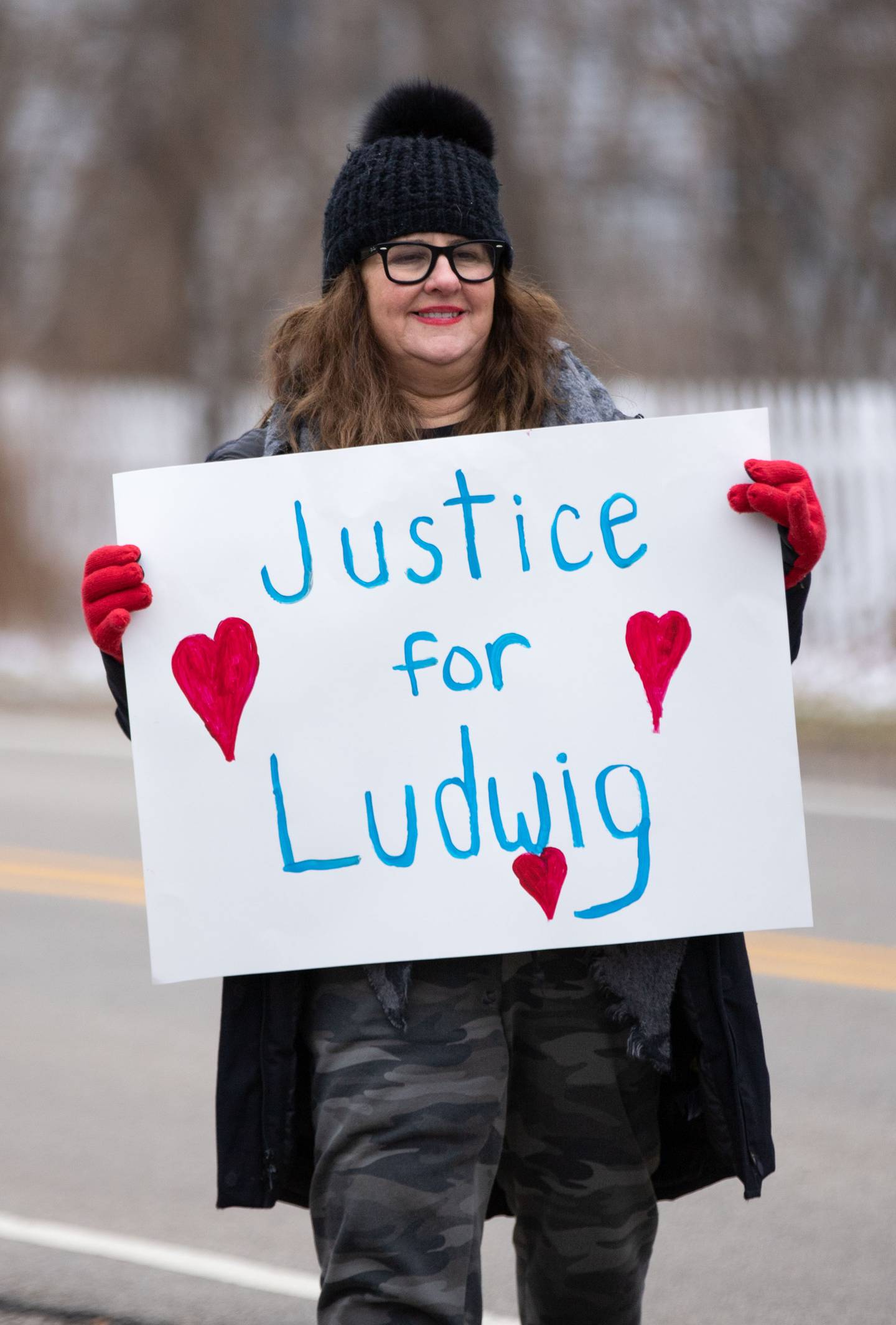 Stephanie Porteous of Campton Hills holds up a sign during the Justice for Ludwig protest outside the Little Home Church by the Wayside in Wayne on Saturday, Jan. 7, 2023. Inside the church a town hall meeting took place to discuss an architectural review of the village hall and police department.