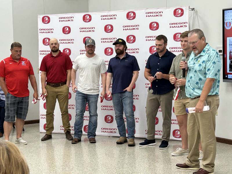 OHS track coach Jim Spratt (right) and assistant coach Dave Hanes (left) stand with members of the 2009 track team after being inducted into the OCUSD Hall of Fame during a ceremony on Saturday, Sept. 14, 2024 at the Rock River Center in Oregon. The team won the Class A title in 2009.