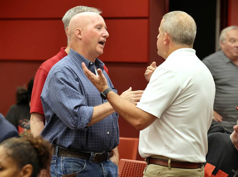 Dan Sears (front left) of D-N-J Properties, and owner of the building at 128 to 140 S. Second Street, along with his brother Joe Sears (back left) engage in a discussion with DeKalb Mayor Cohen Barnes (right) Monday, July 10, 2023, before the DeKalb City Council meeting. The city council has plans to consider acquiring and demolishing the 133-year-old building owned by Sears to provide space for additional downtown parking.