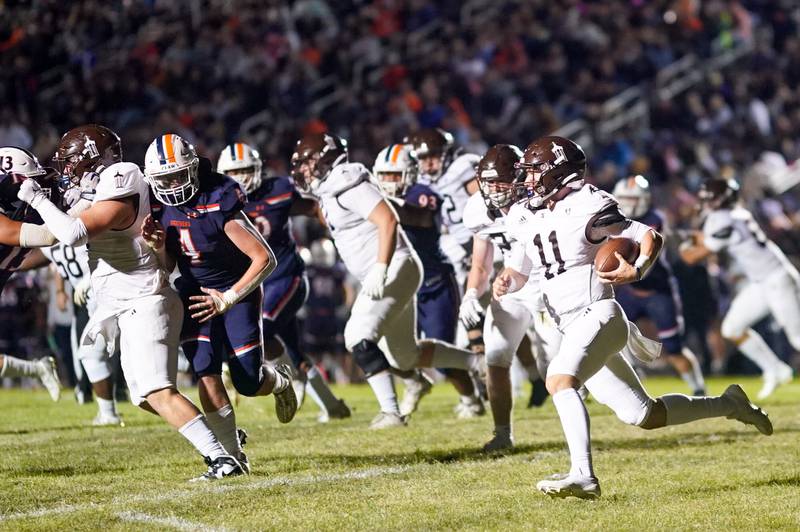 Joliet Catholic's Lucas Simulick (11) carries the ball on a keeper against Oswego during a football game at Oswego High School on Friday, Sep 6, 2024.