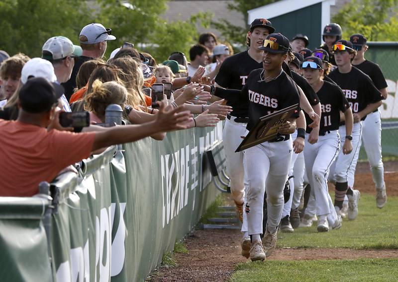 Crystal Lake Central's Jaden Obaldo leads his teammates as they high five the fans after defeating Deerfield 6-2 in the Class 3A Grayslake Central sectional championship baseball game on Friday, May 31, 2024, at the Grayslake Central High School.