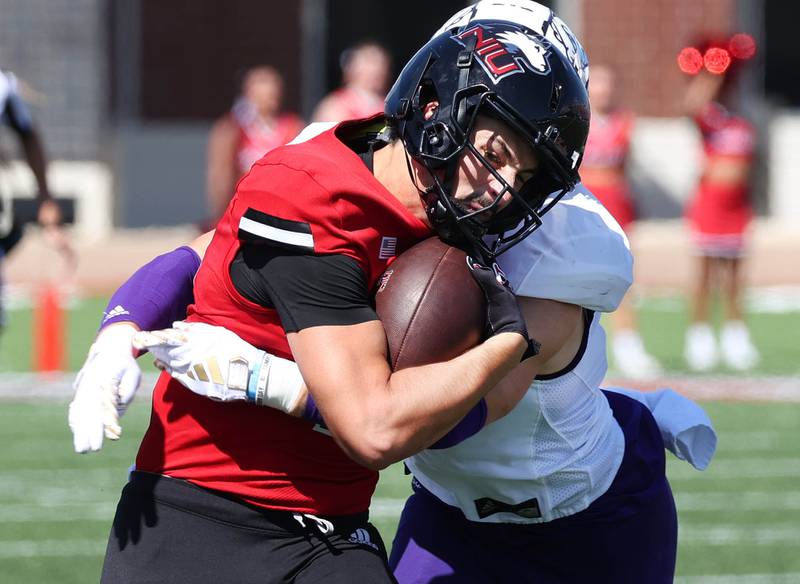 Northern Illinois quarterback Ethan Hampton takes a shot from Western Illinois' Noah Epley after a big gain during their game Saturday, Aug. 31, 2024, in Huskie Stadium at NIU in DeKalb.