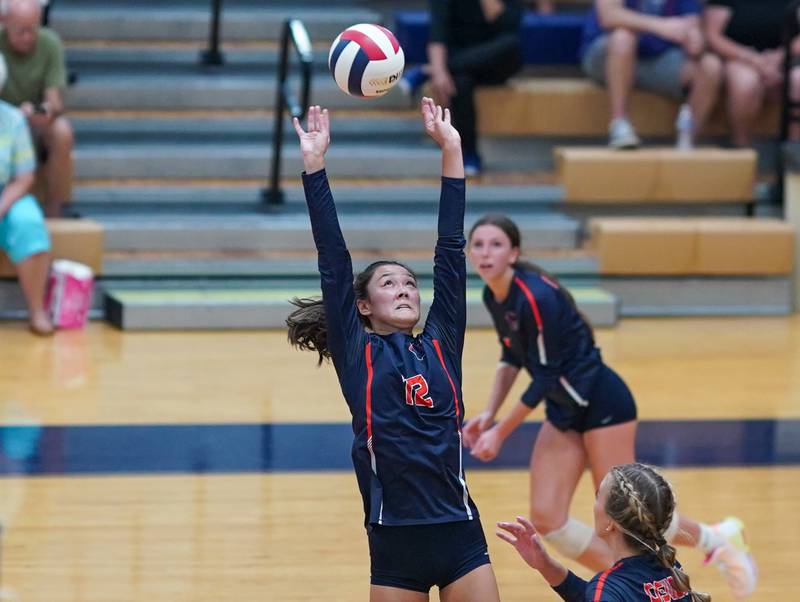 Oswego’s Ava Flanigan (12) sets the ball against Rosary during a volleyball match at Oswego High School on Tuesday, Aug 29, 2023.