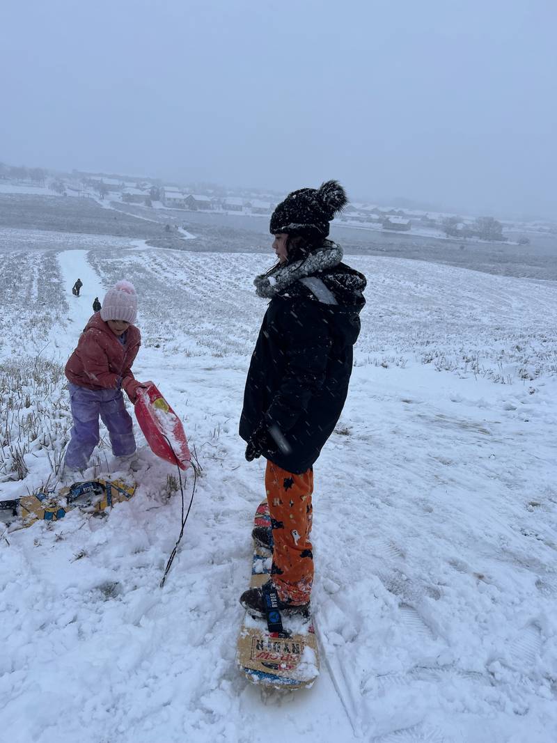 Sisters Olivia, 6, and Evalina, 10, of Lake in the Hills, enjoy the snow snowboarding on Tuesday, Jan. 9. 2024, in Algonquin.