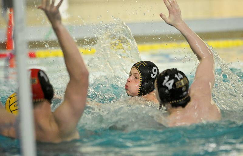 Lyons’ Brendan Whelton and Declan Vahey, right, defend the net with goalkeeper Charlie Vlk in the IHSA boys water polo championship against Stevenson in Lincolnshire on Saturday, May 18, 2024.