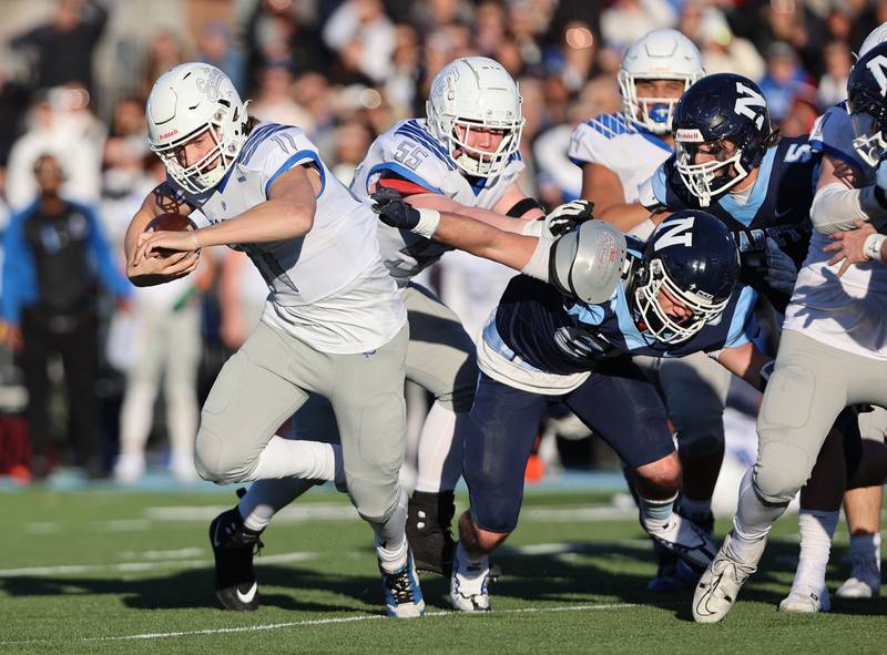 St. Francis' Alessio Milivojevic (11) is chased down by Nazareth's Nolan Daly (60) during the boys varsity IHSA 5A semifinal between Nazareth Academy and St. Francis high school in La Grange Park, IL on Saturday, Nov. 18, 2023.