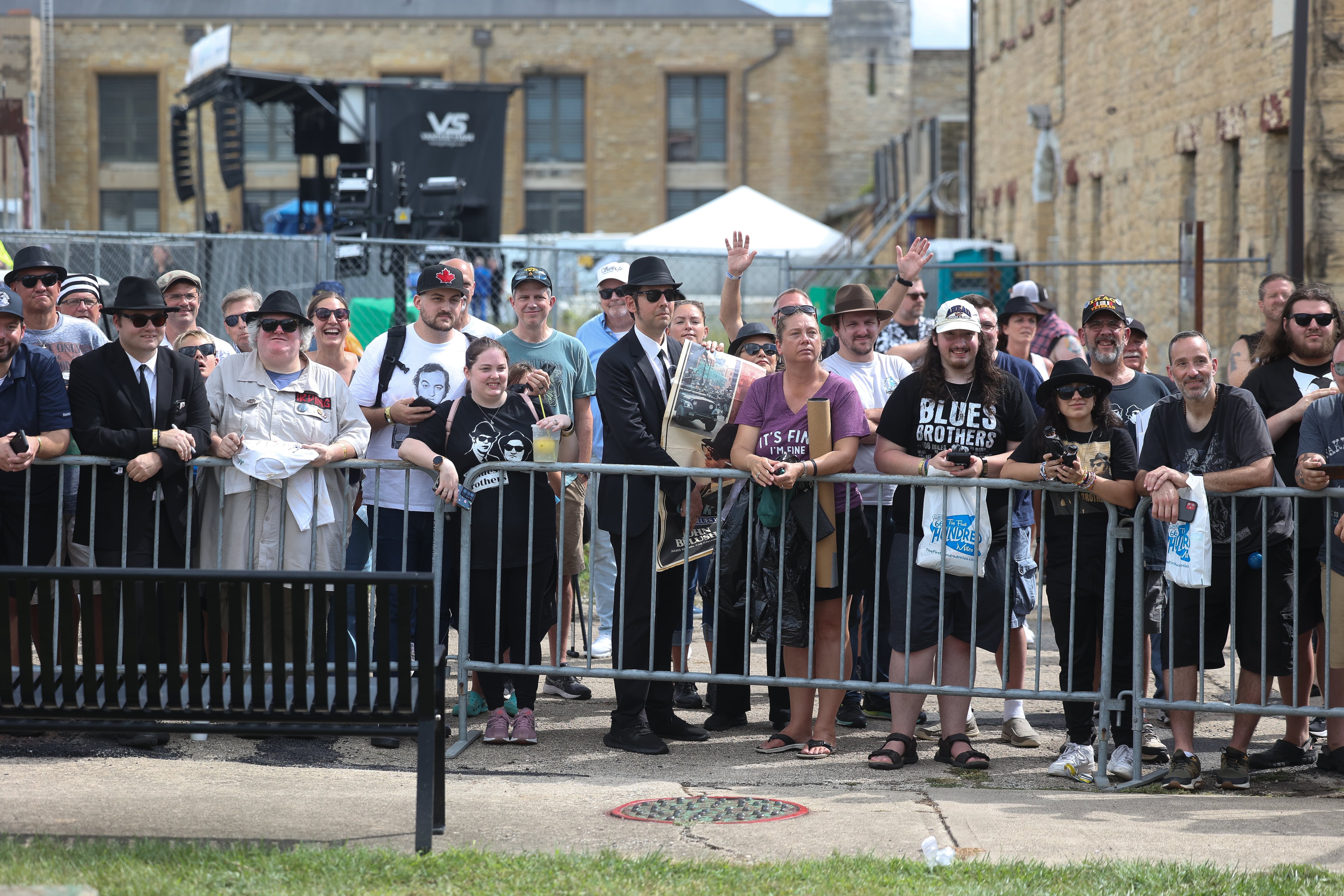 Fans line a fence as Dan Aykroyd and Jim Belushi arrive for the Blues Brothers Con: The Sequel on Saturday, Aug. 17, 2024 at the Old Joliet Prison.