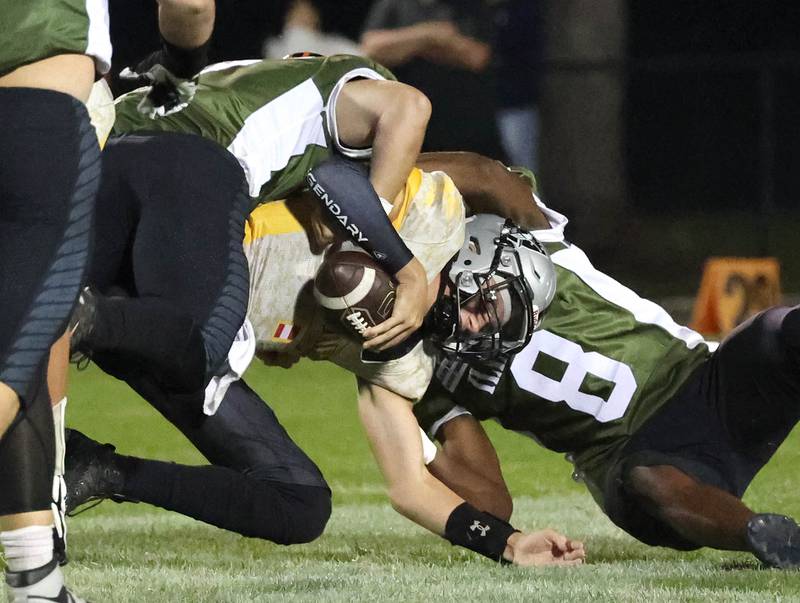 DeKalb's Matthew Clayton (left) and DeKalb's Justin O’Neal sack Kaneland's Chase Kruckenber during their game Friday, Sept. 13, 2024, at Kaneland High School in Maple Park.