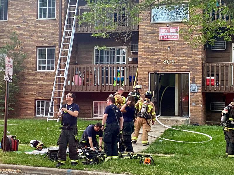 DeKalb firefighters take turns grabbing water and suiting up while crews from multiple DeKalb County agencies work to battle a structure fire at a Husky Ridge apartment complex in the 800 block of Kimberly Drive, DeKalb, on Wednesday evening, May 29, 2024.