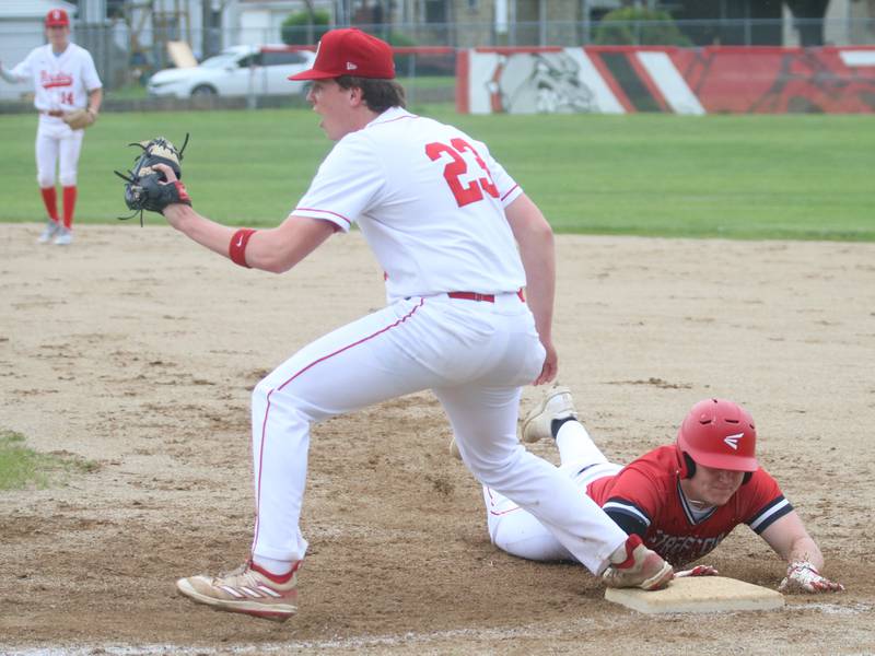 Streator's Cole Winterrowd dives back into the bag at first as Ottawa's Jackson Mangold waits for the late throw on Tuesday, May 14, 2024 at Streator High School.