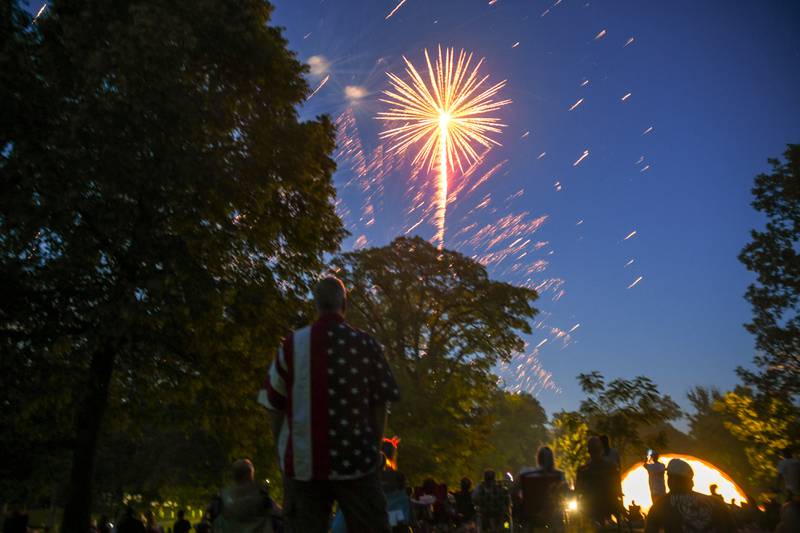 Doug Olson of DeKalb watches fireworks go off over the Dee Palmer Bandshell at Hopkins Park in DeKalb as the DeKalb Municipal Band plays on Tuesday, July 4, 2023 during DeKalb's annual Fourth of July celebration.