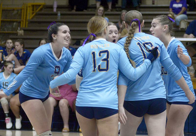 The Marquette Lady Crusaders celebrate a point that brings them closer to tying Lexington in the first match Tuesday at Marquette.