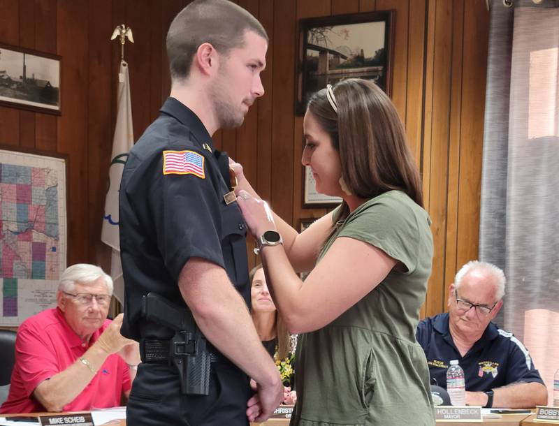 Just promoted Marseilles Police Department Captain Jim Buckingham has his captain ensignia pinned on by his wife, Ashley, at Wednesday's Marseilles City Council meeting.