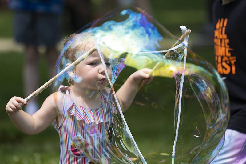 Charli Myer, 3, of Sterling blows into a huge bubble Saturday, July 13, 2024 at Sterling’s Chalk the Walk, where 142 kids signed up to take part in the fun.