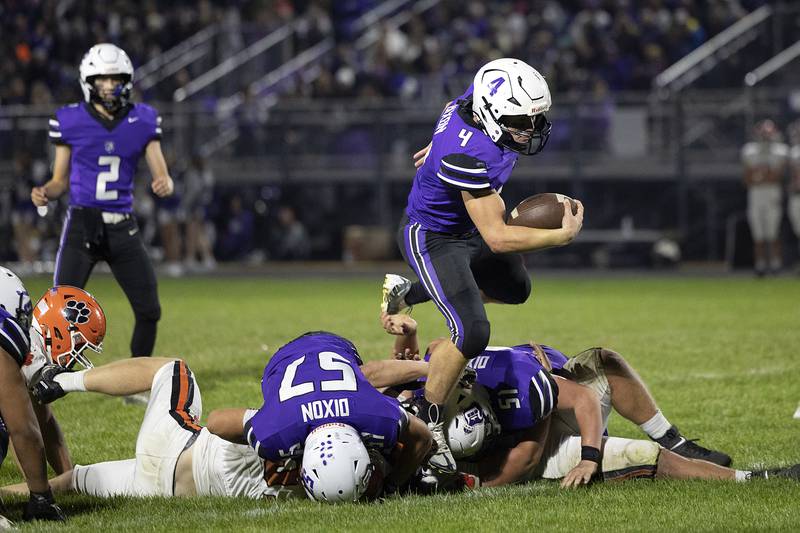 Dixon’s Landon Knigge leaps over a pile against Byron Friday, Oct. 18, 2024, at A.C. Bowers Field in Dixon.