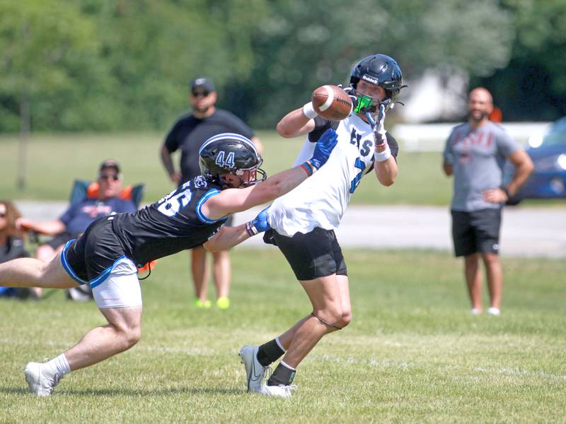 Lincoln-Way East’s Trey Zvonar makes a catch as he’s trailed by a St. Francis defender during a 7-on-7 tournament in July 2024 at Naperville North.