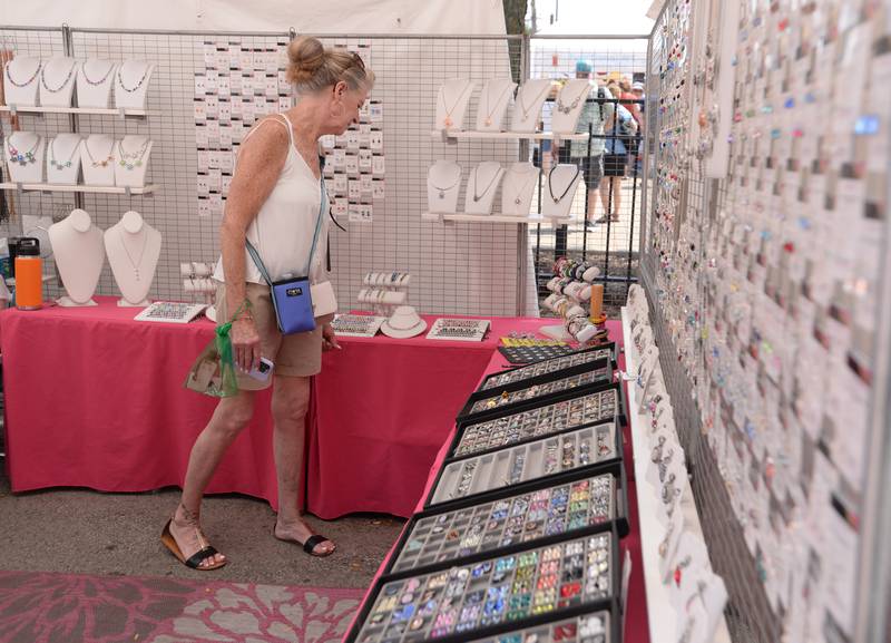 Lynn Serafini of Lombard looks over some of the Beadazzle jewelry at the LaGrange Craft Fair held Saturday, July 13, 2024.