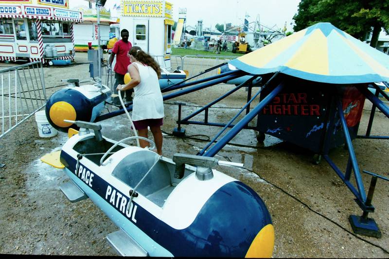 Dwight Webster and Cheryl Mannon set up the Space Patrol Ride during the Bureau County Fair in 1999.