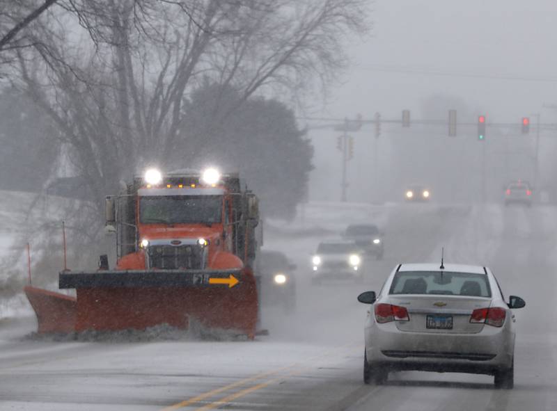 A snowplow plows and salts South Crystal Lake Road in McHenry as snow falls Thursday, Dec. 22, 2022, as a winter storm hits northern Illinois.