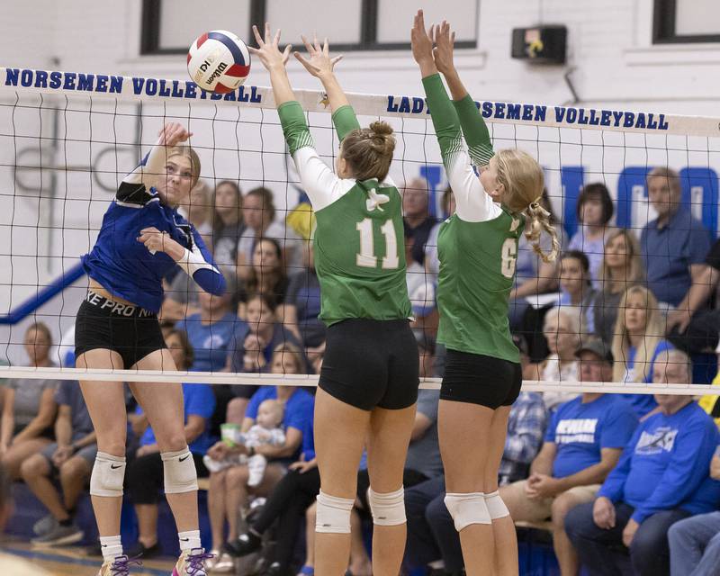 Adrianna Larson of Newark spikes the ball past the reach of two Seneca's Graysen Provance and Franki Meyers during the match at Newark High School on September 9, 2024.