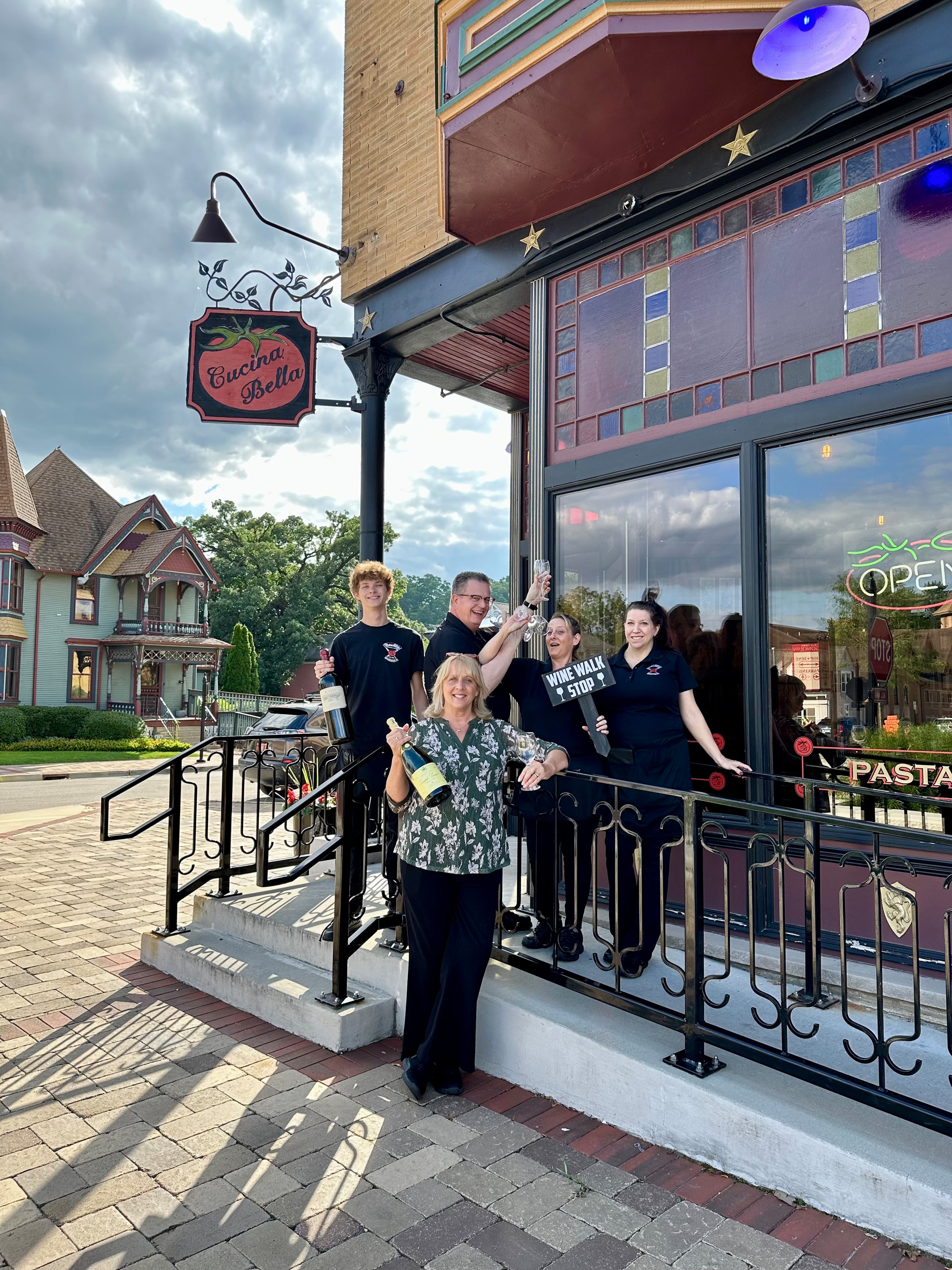 Cucina Bella staff stand outside of the restaurant and will be of the 15 stops at the Summer Lovin' Wine Walk on Aug. 17, 2024.