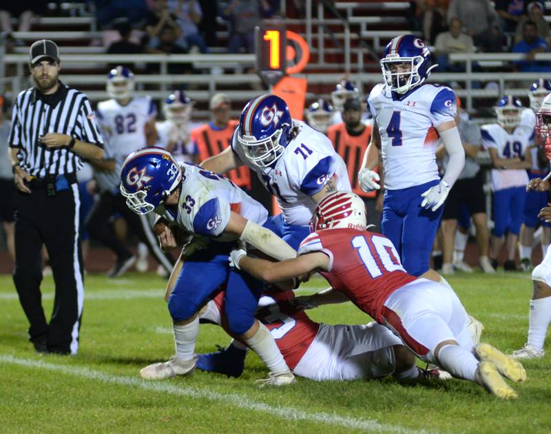 Genoa-Kingston's Owen Zaccard (33) fights for yards as Oregon's Ethan Mowry (3) and Keaton Salisbury (10) defend during action against Oregon on Friday, Sept. 13, 2024 at Landers-Loomis Field in Oregon.